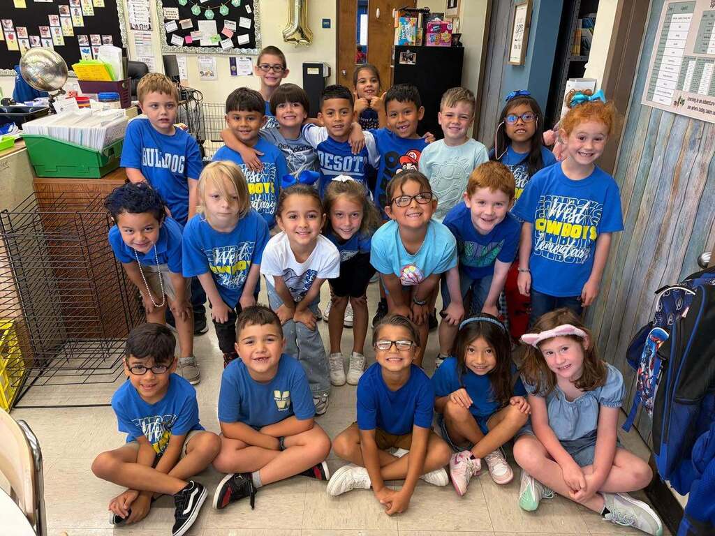 group of kids wearing blue shirts and smiling