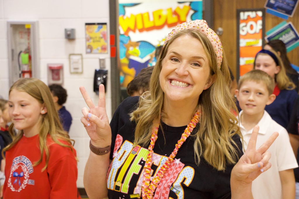 Tewacher smilies giving peace sign