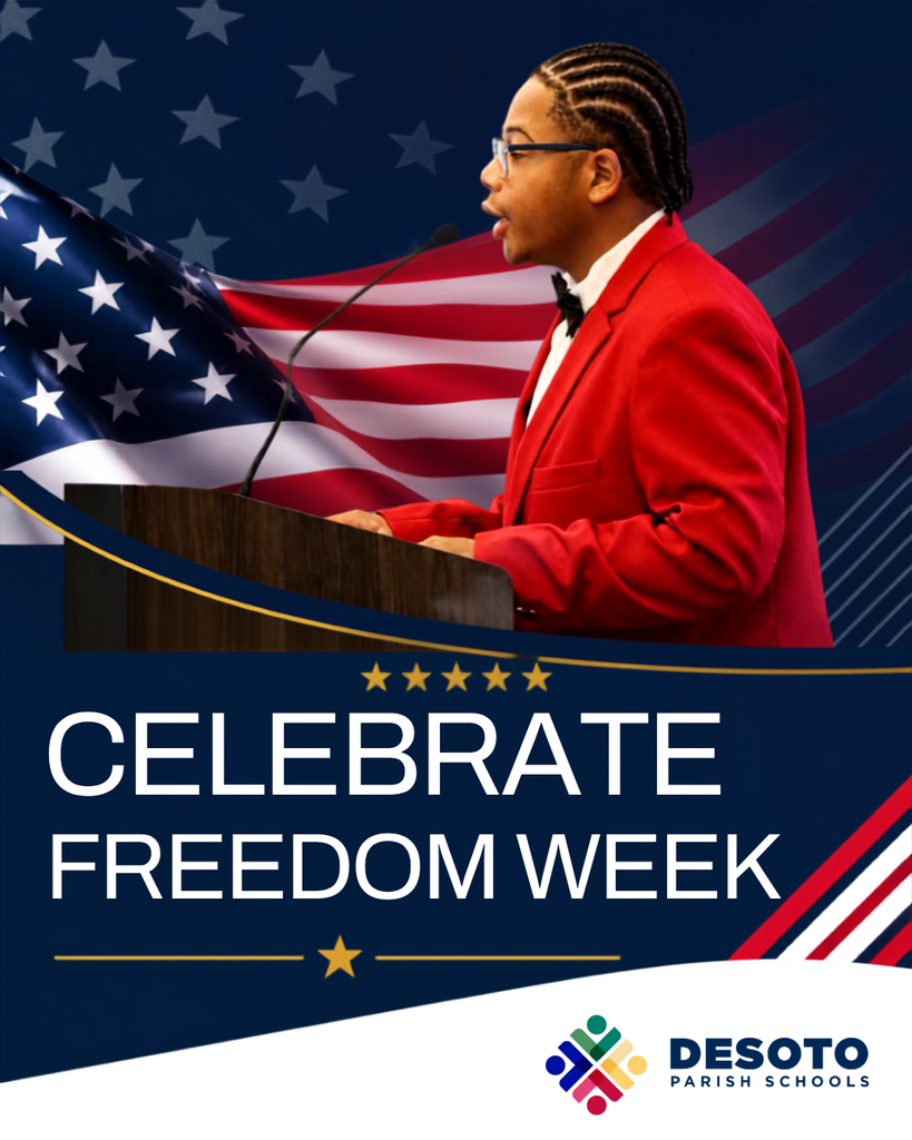Person stands at podium in red suit, speaking into microphone with American flag in background. Text reads "Celebrate Freedom Week".