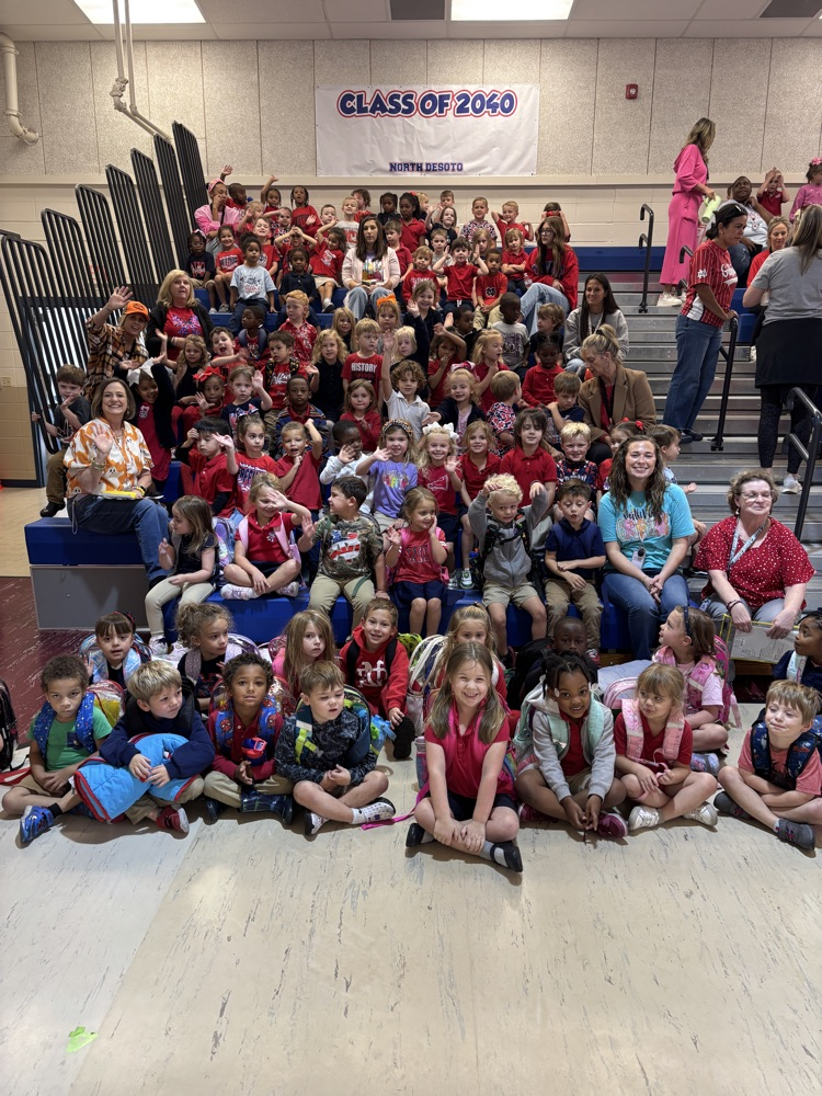 Group of students sitting in rows on a bleacher. A banner with the text "Class of 2060" is visible.