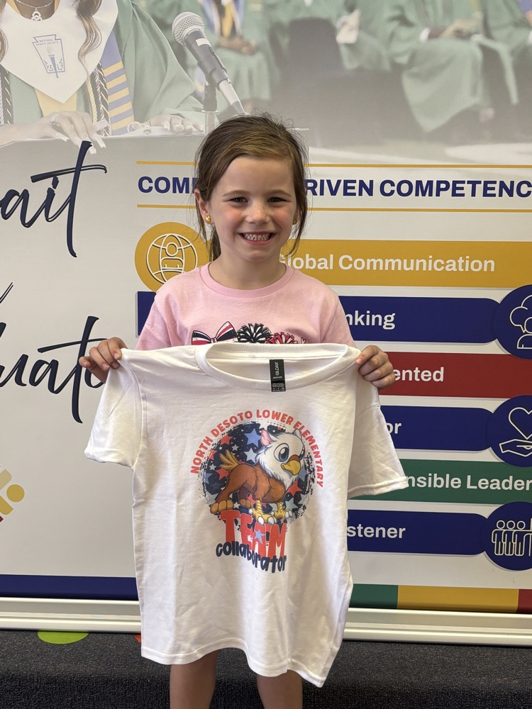 Young girl holds up white T-shirt with printed design of bird and text over her shoulder.