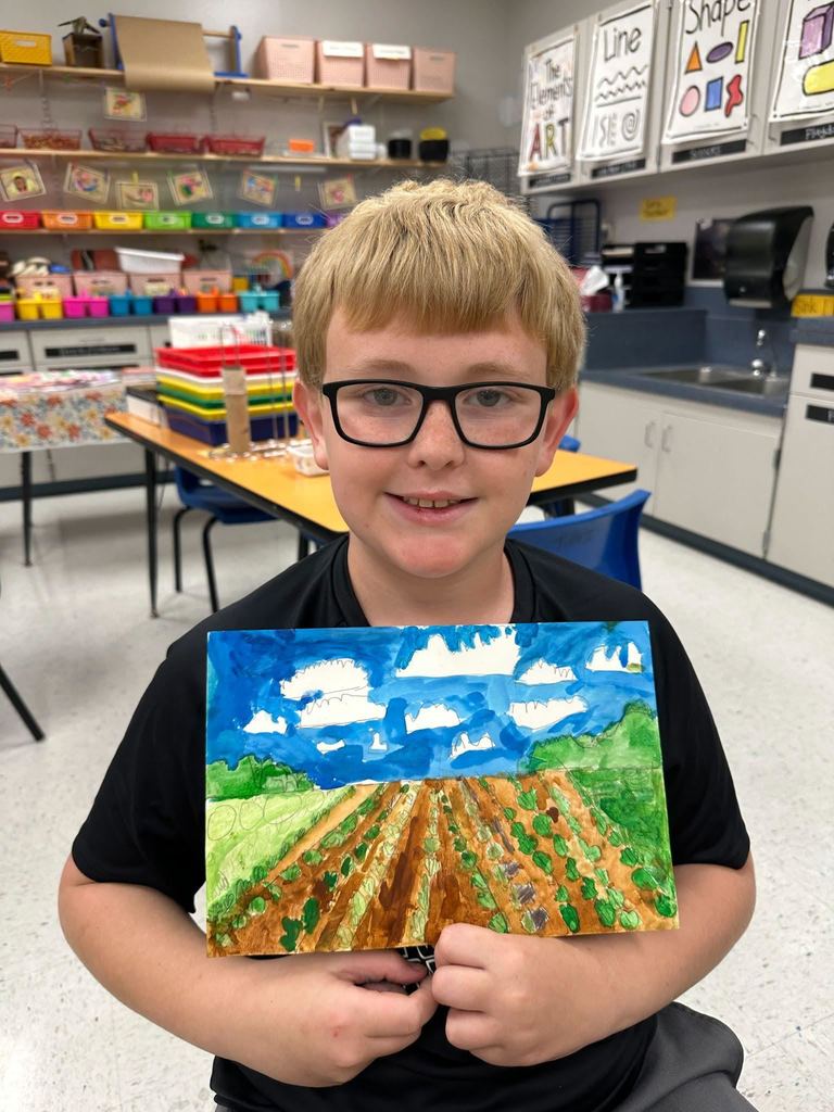 Student posing with their landscape picture