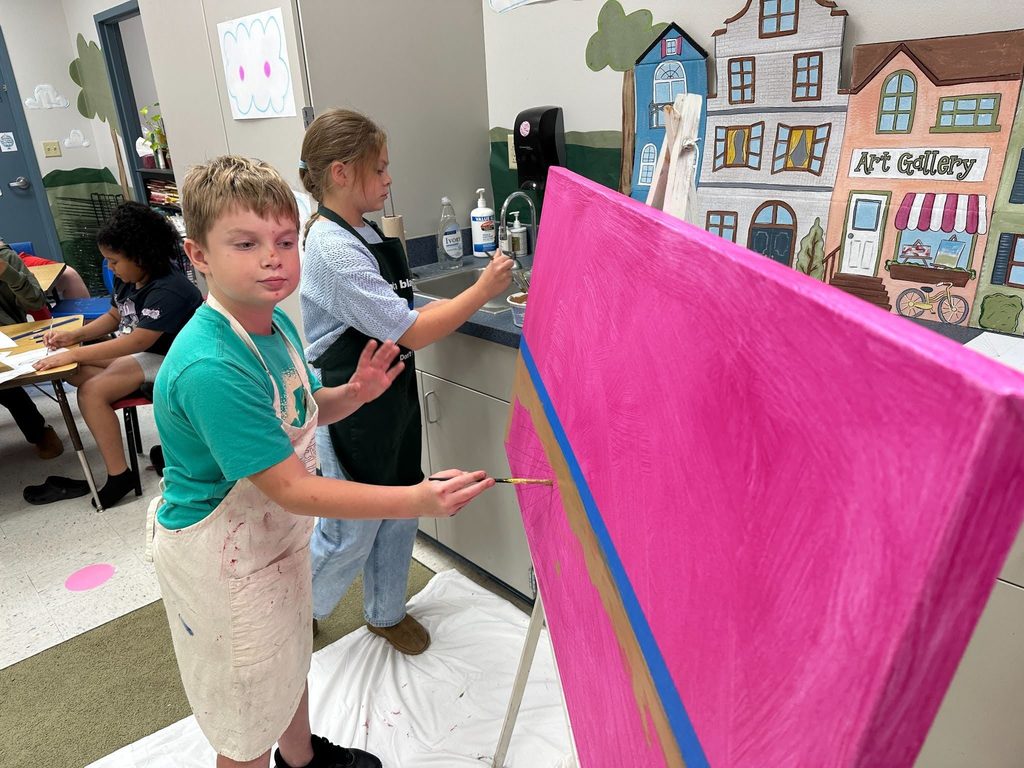 students painting a landscape on a canvas