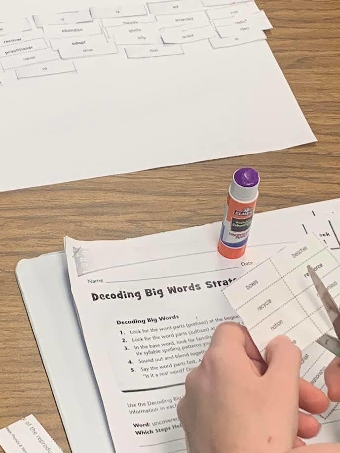 students cutting and pasting words