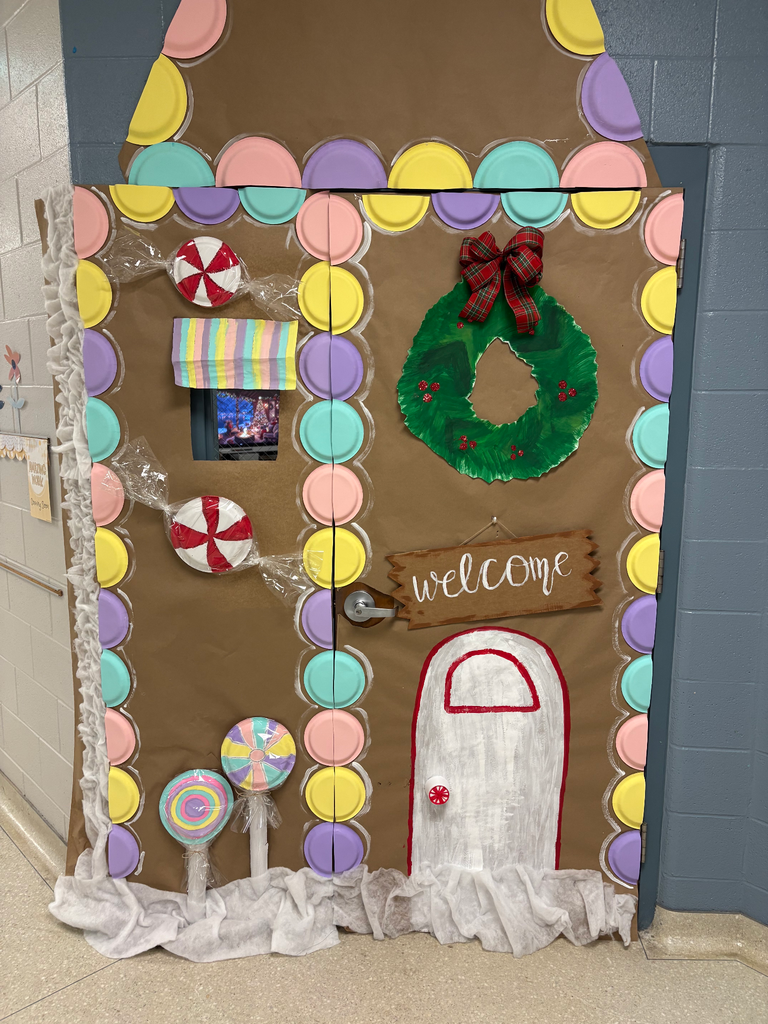 A door decorated to look like a gingerbread house with pastel gum drops all around