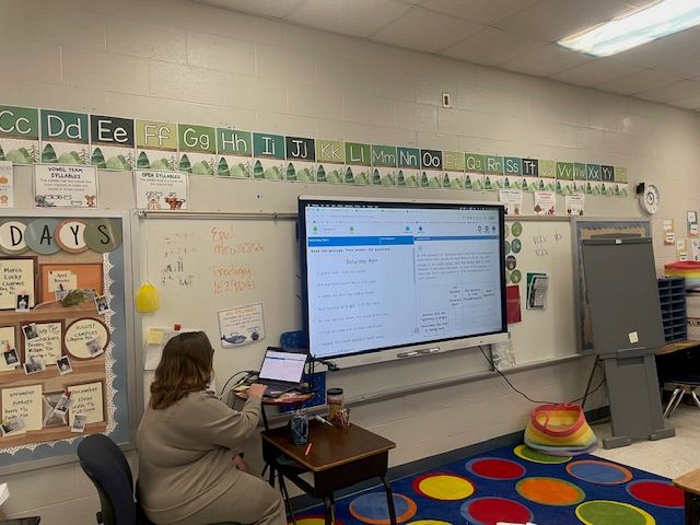 Teaching working with students at the front of the classroom using a smartboard
