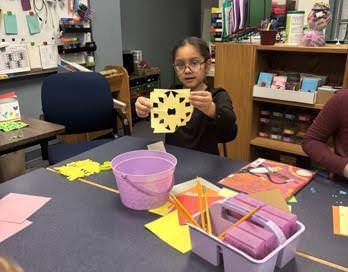 Students using scissors to cut snowflakes