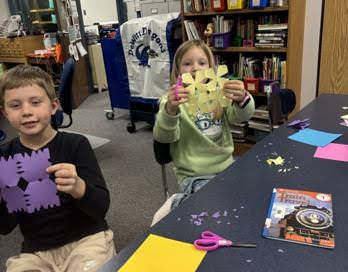 Students using scissors to cut snowflakes