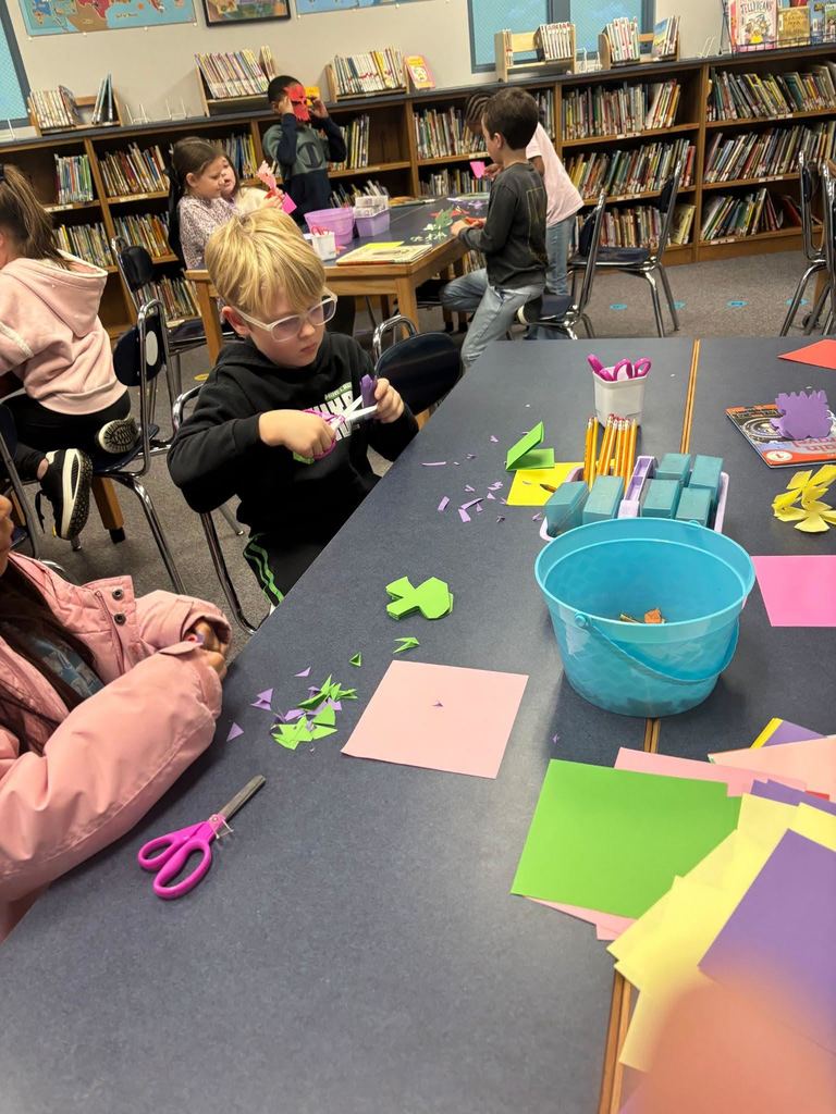 Students using scissors to cut snowflakes