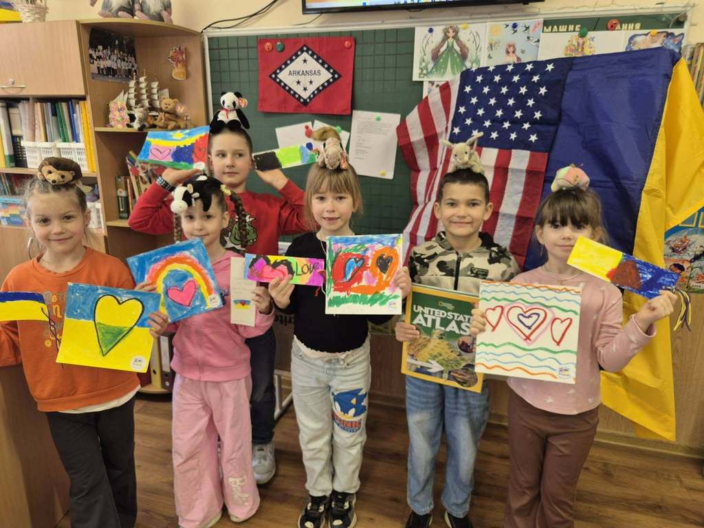 Students in Ukrain posing with artwork created and sent to them by DES Students