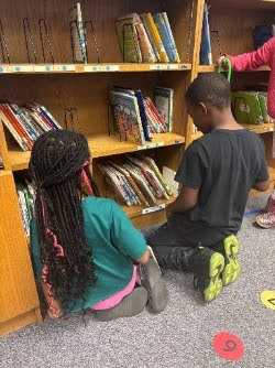 Students looking at books on the bookshelf