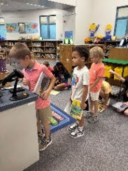 students in line to check out a book at the circulation desk