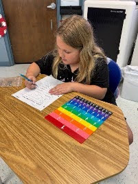 female student working with math fraction tiles
