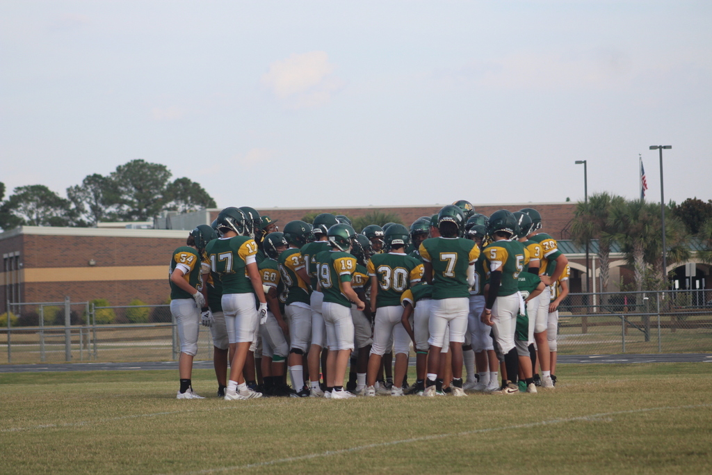 Football players in huddle.