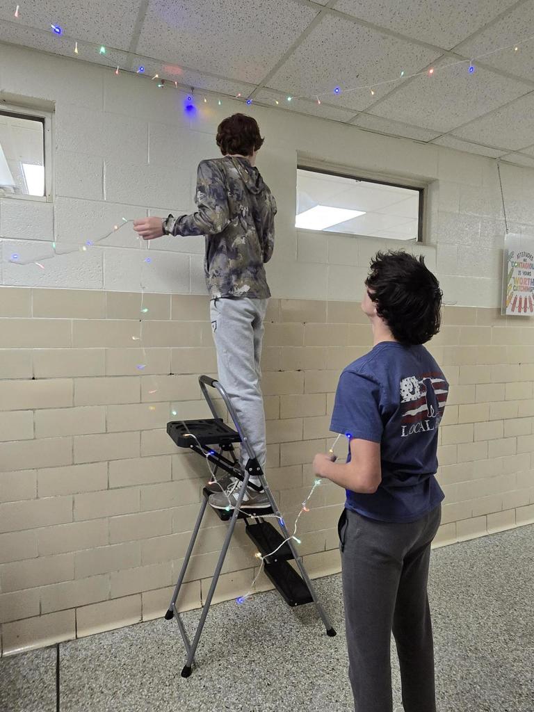 Students work to string lights.