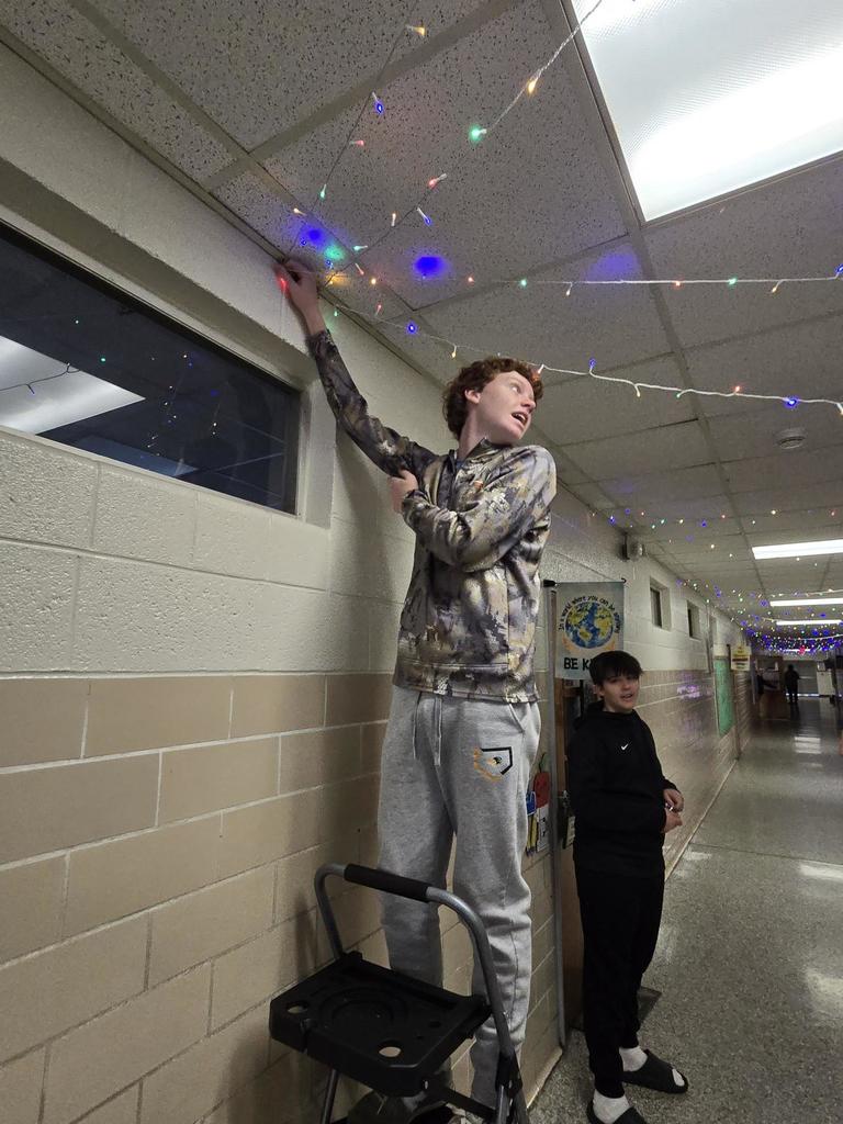 Student works to string lights.