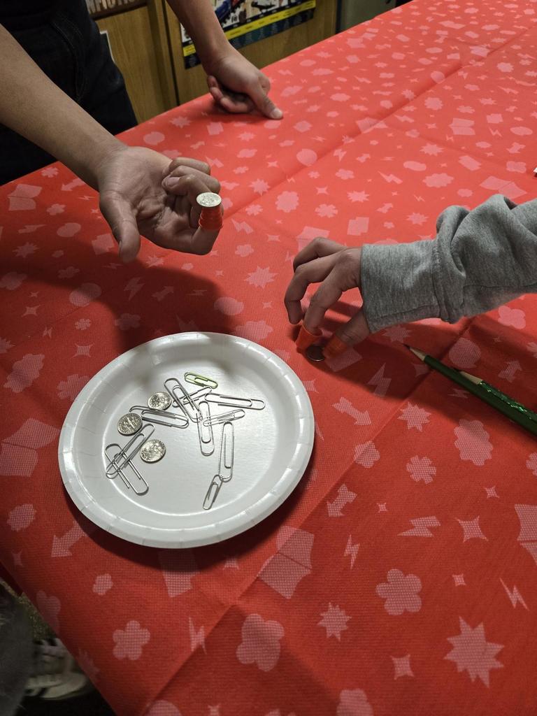 Students place thimbles on their thumbs and attempt to pick up paper clips and coins to simulate physical/sensory limitations.