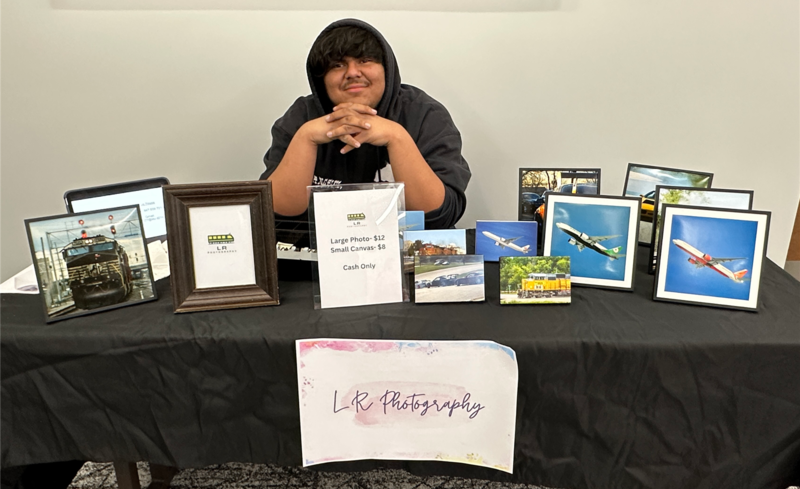 D214 life student Luis Reyes proudly displays his photos for sale.