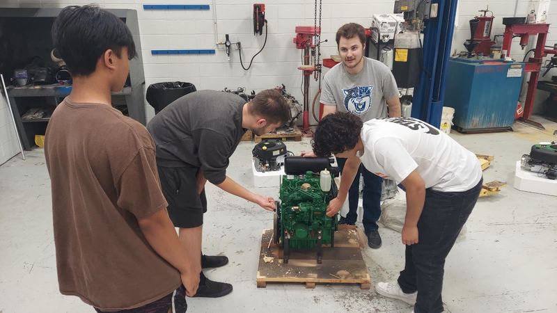 Wheeling High School 2019 graduate Shane Rayburn (second from right) teaches in the autos program at his alma mater.