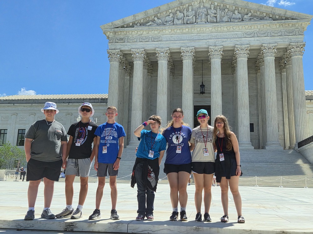 students in front of monument