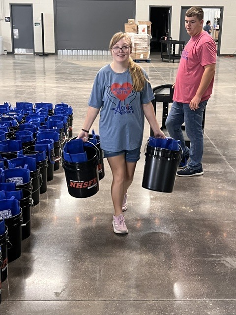student carrying buckets