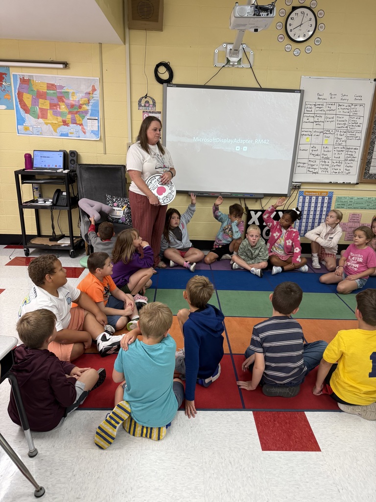 Mrs. Andrews with second graders at the carpet completing the wish well ritual