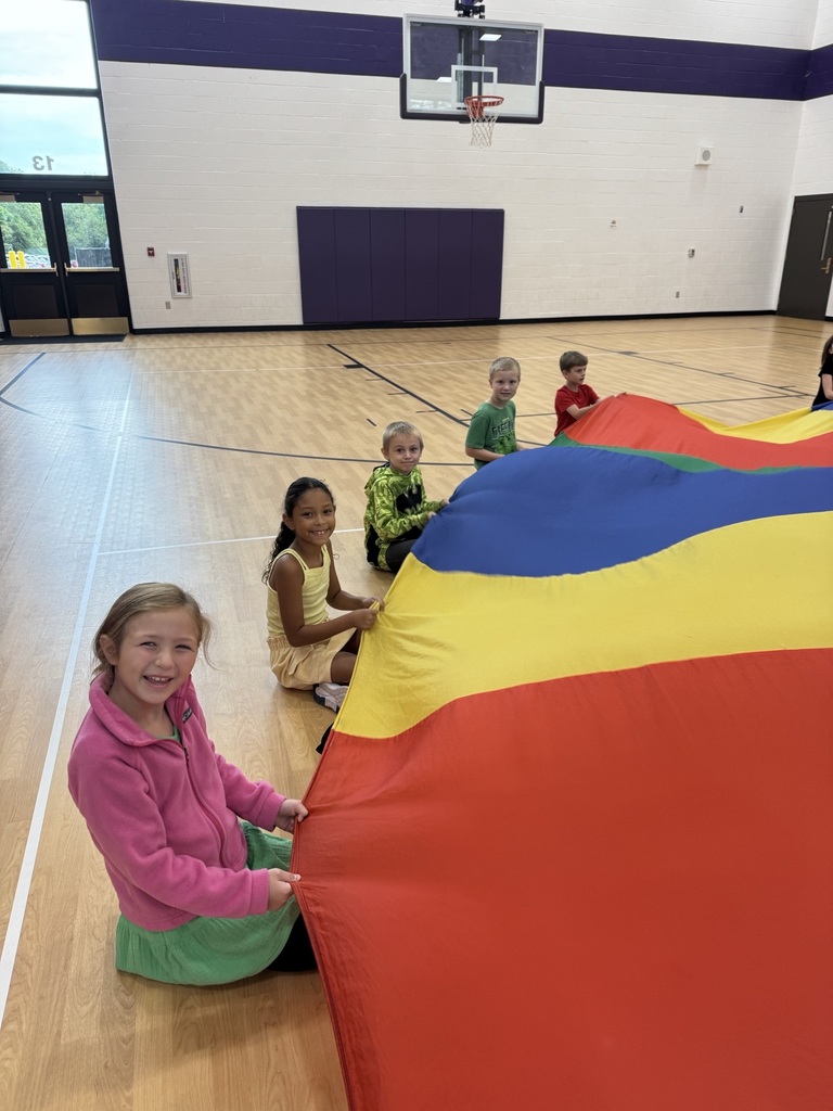 students in third grade playing with the parachute 
