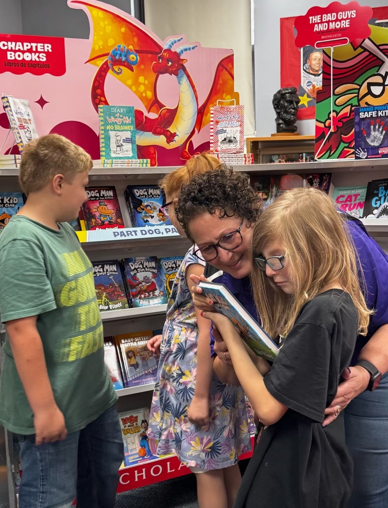 Our school librarian checks out a book with a student 
