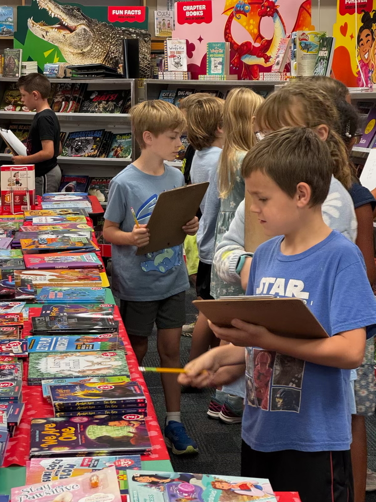 third graders look through the many books for sale 