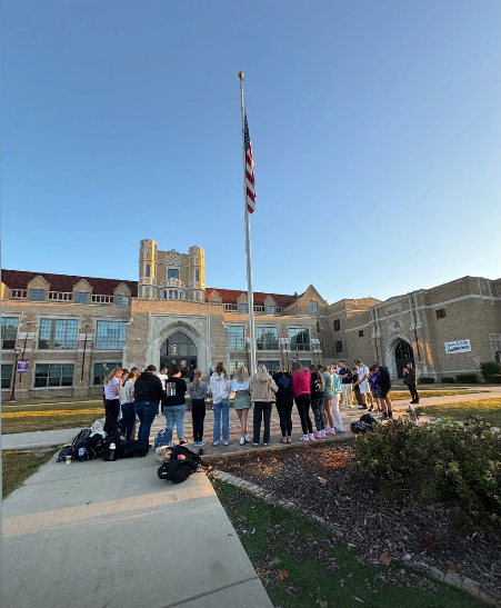 students representing their faith around flag pole