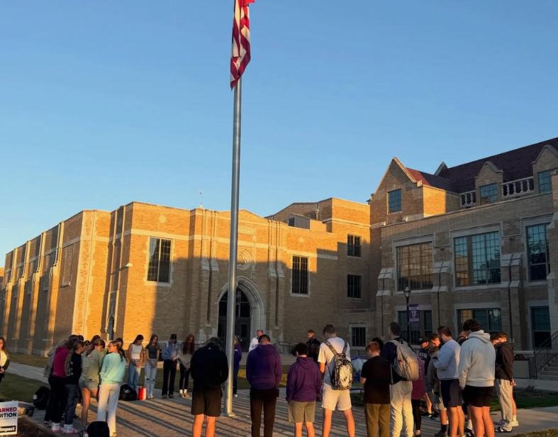 students representing their faith around flag pole