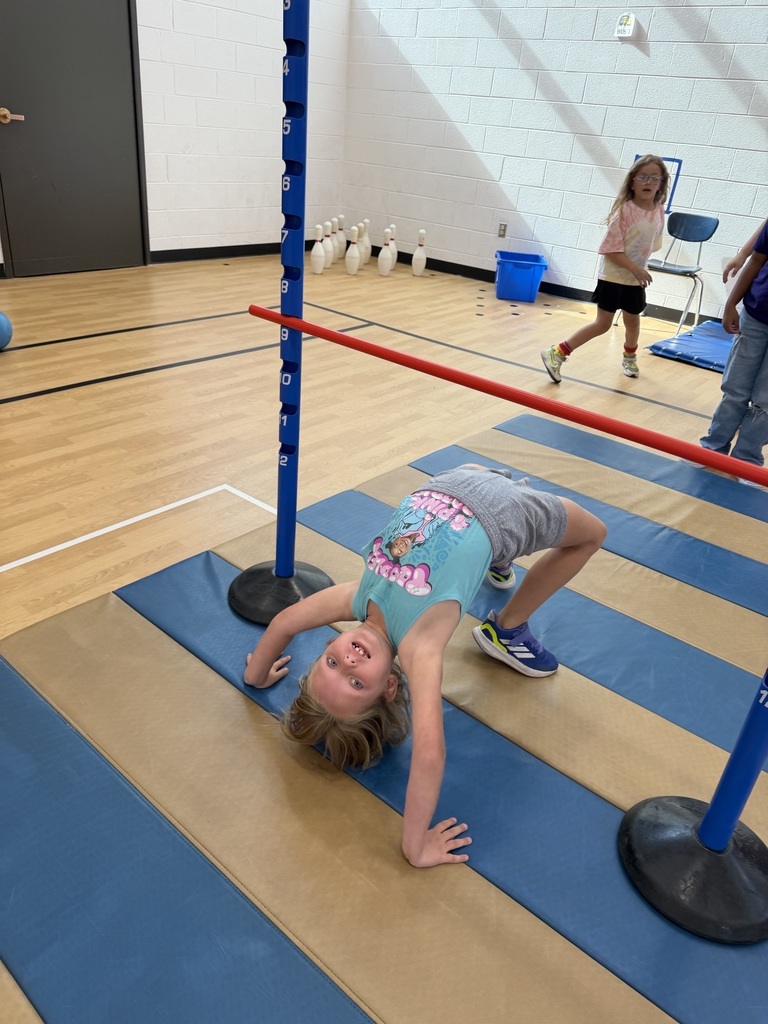 student doing a back bend under the limbo stick in fitness friday
