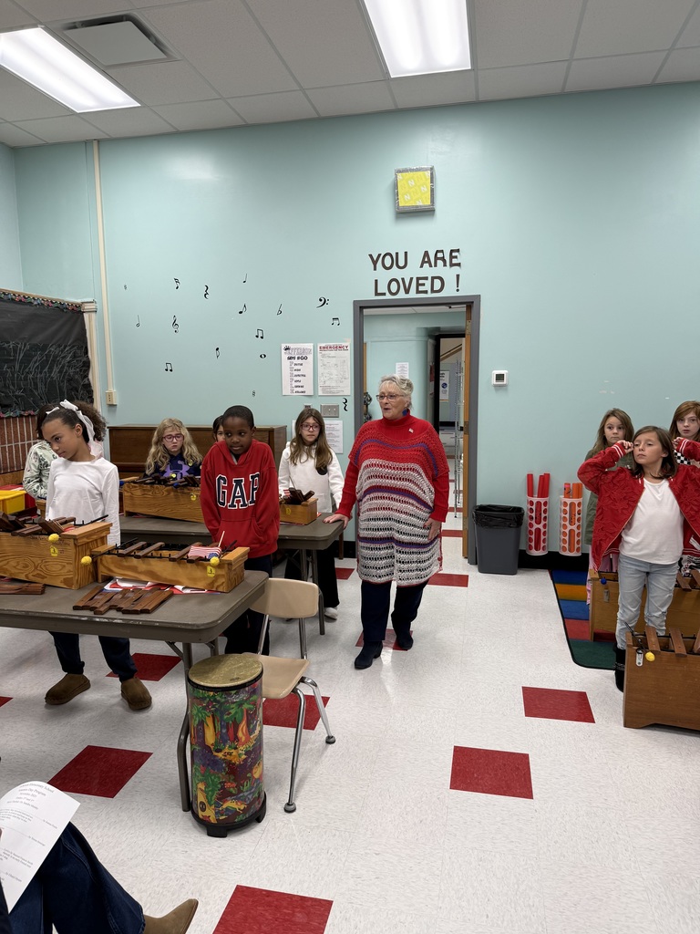 3rd grade students in music class preparing for the Veteran's Day concert with their teacher, Dr. Malahey.