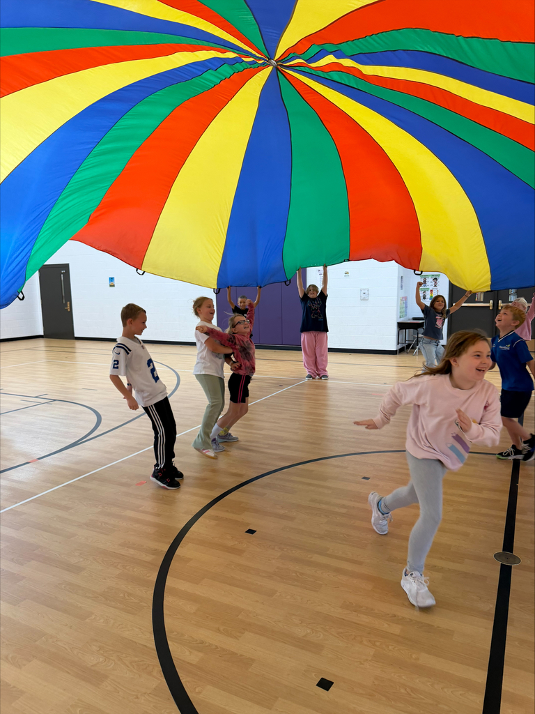 3rd graders playing with the parachute in PE 
