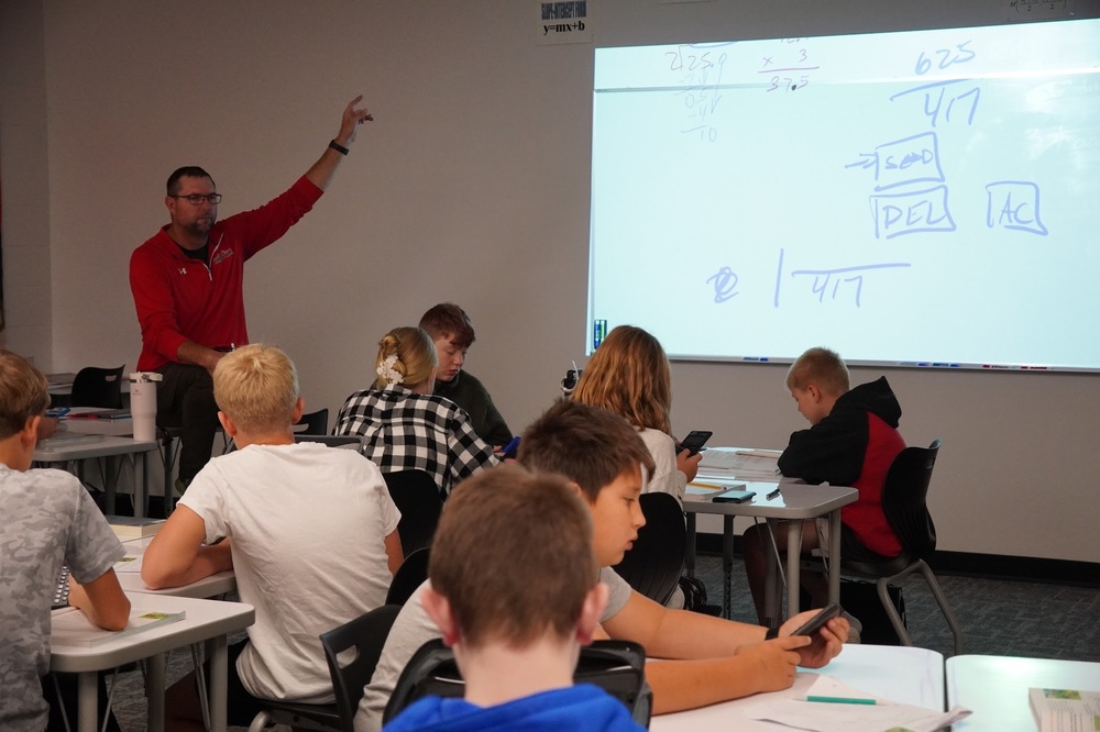 Mr. Bivens teaches a class of 7th-grade students a math lesson in the new, more spacious classroom.
