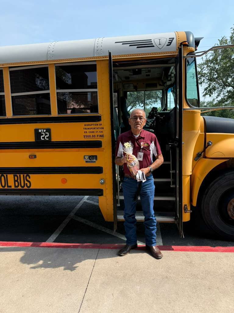 man in maroon shirt with yellow bus 