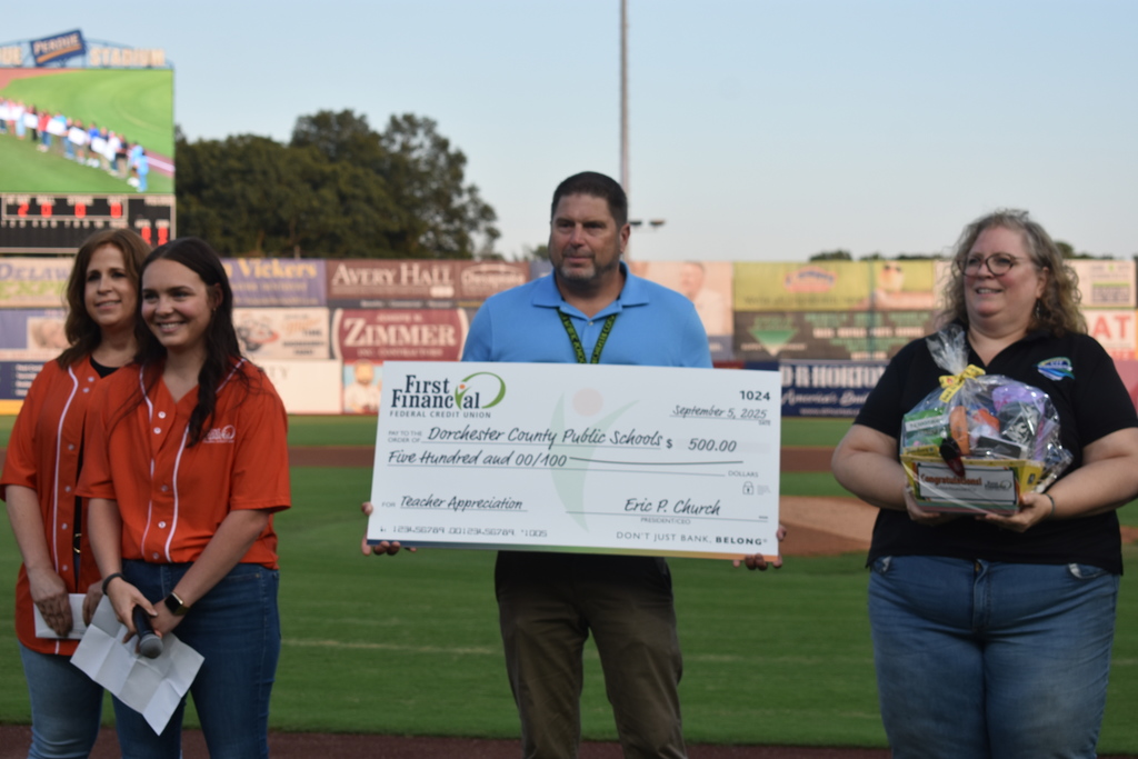 Assistant Superintendent, Dr. Michael Collins, accepts a $500 check presented by First Financial on behalf of DCPS