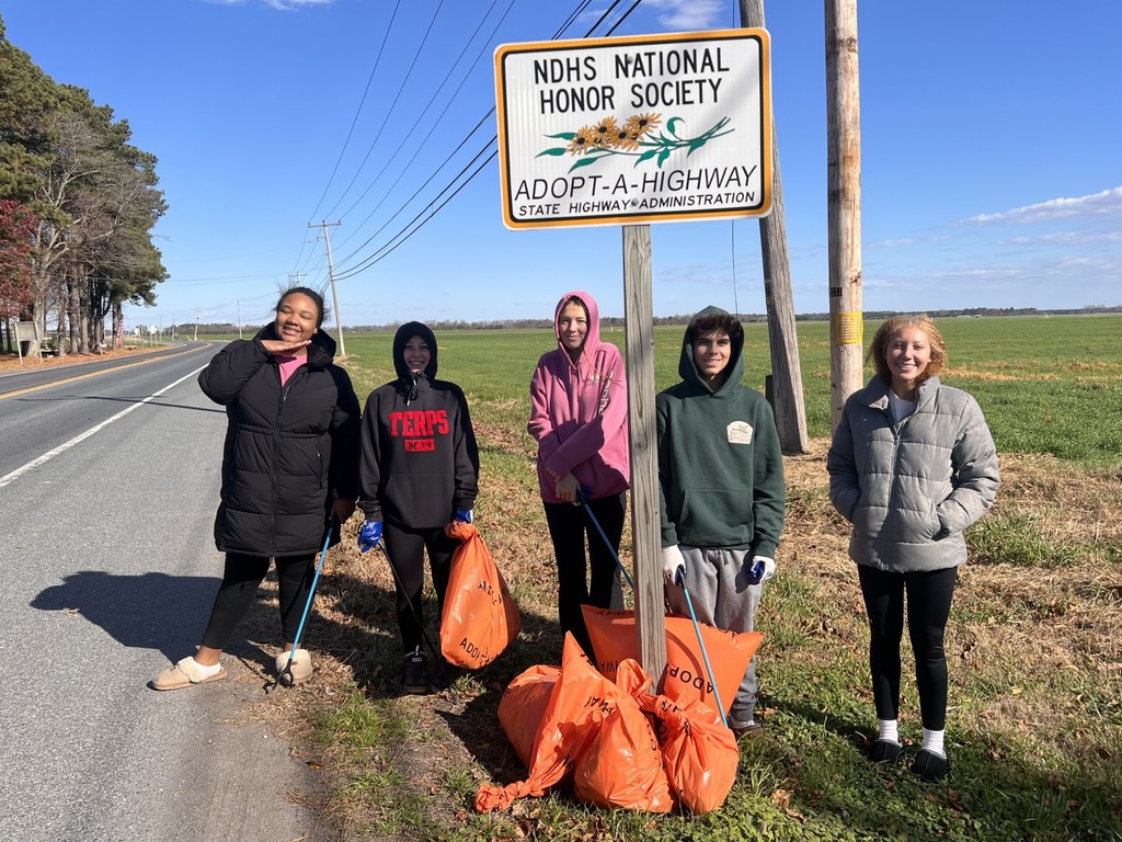 students posing with a highway cleanup sign