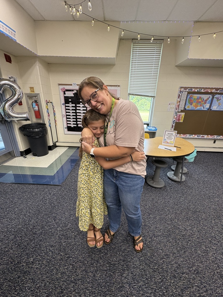 Teacher and student hugging at open house