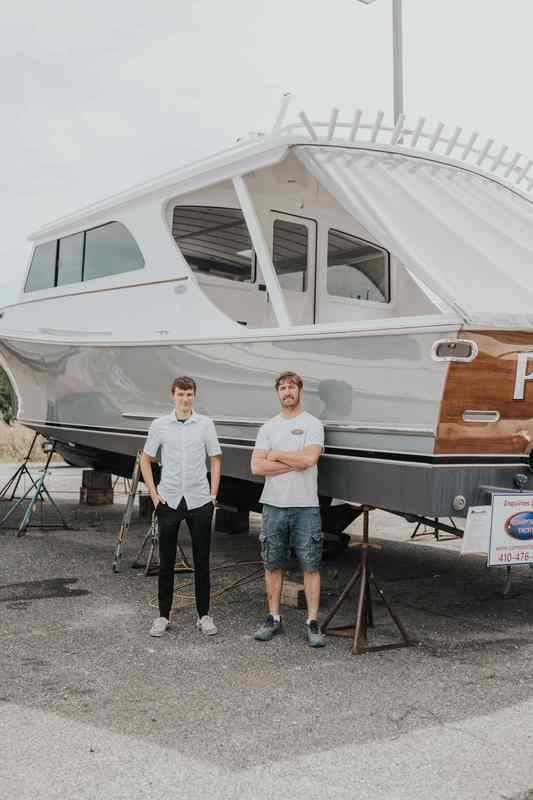 two men standing in front of boat