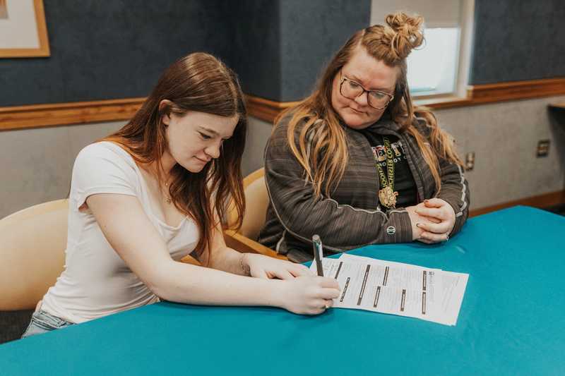 Evelyn signing her apprenticeship papers
