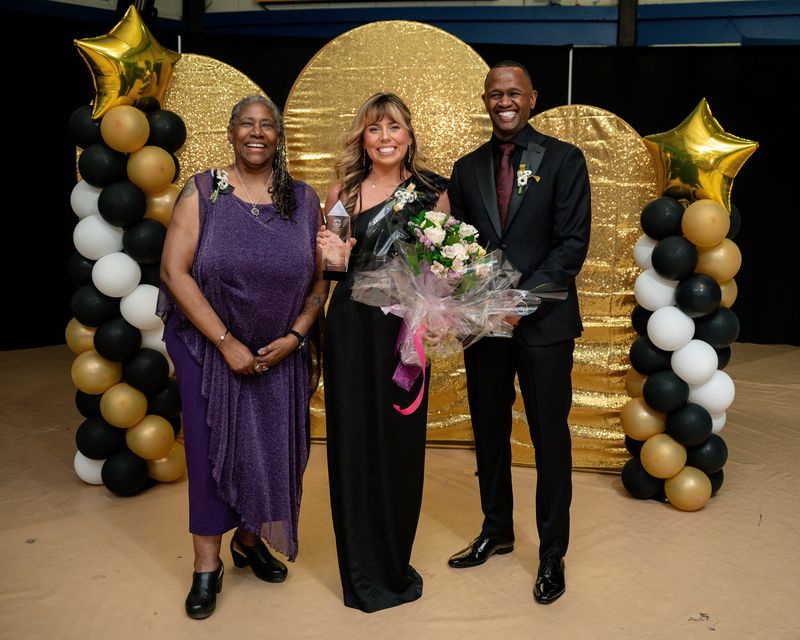teacher of the year standing with the Board of Ed President and Superintendent