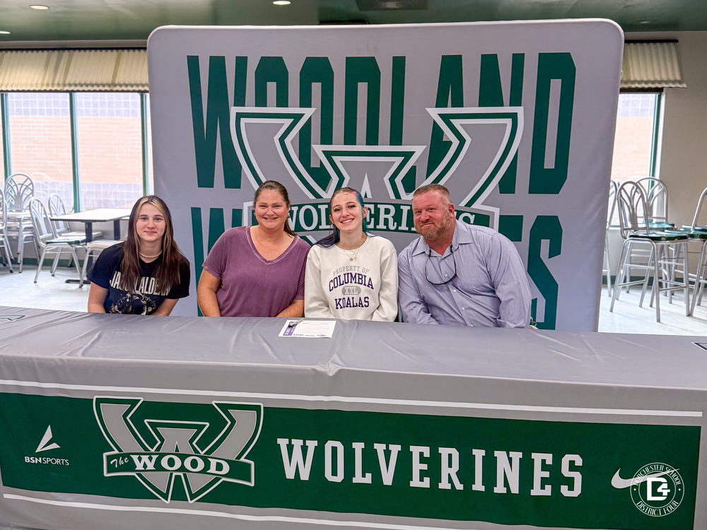 haven main and her family sitting behind a table with a woodland wolverines table cloth.
