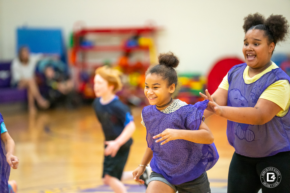 Students running for the ball in the first CHES basketball game