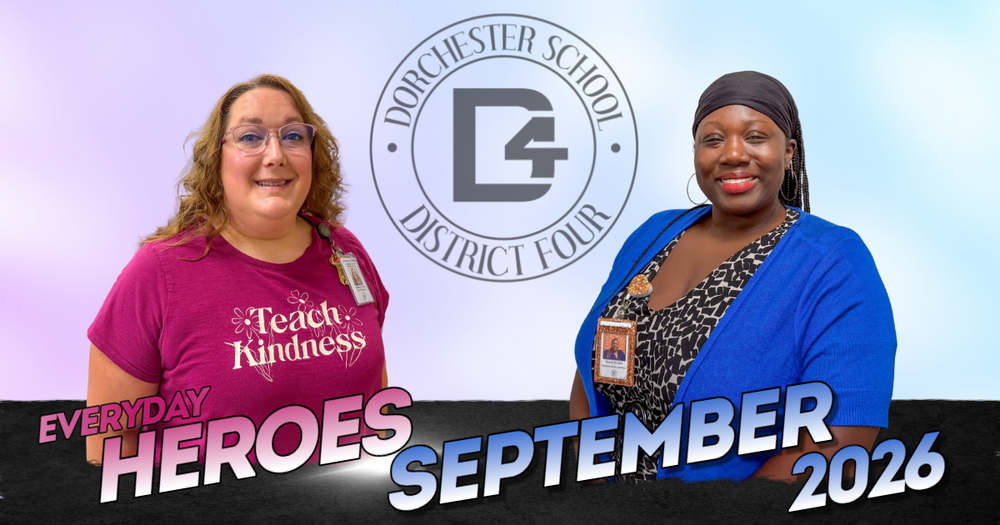 Everyday Heroes September 2026 graphic for Dorchester School District Four. Two smiling staff members stand on either side of the district's circular D4 logo against a soft purple and blue background. On the left, a woman with curly hair and glasses wears a magenta "Teach Kindness" T-shirt and a district ID badge. On the right, a woman in a black headwrap and hoop earrings wears a bright blue cardigan over a patterned top with a district ID badge. Bold text across the bottom reads "Everyday Heroes September 2026."