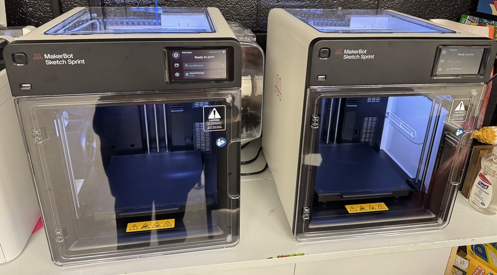 2 3D printers, make is the MakerBot Sketch Sprint.