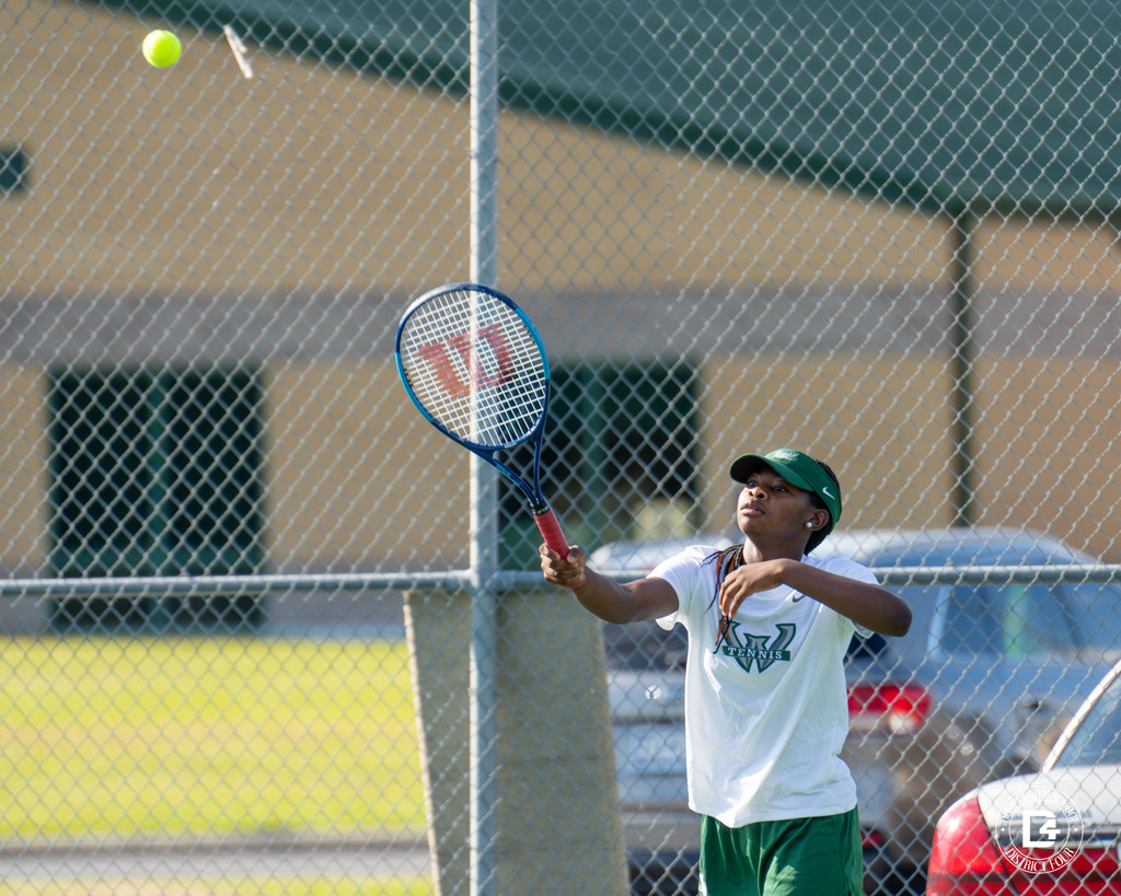 A Woodland High School tennis player prepares to return a shot, eyes on the ball as she extends her racket.