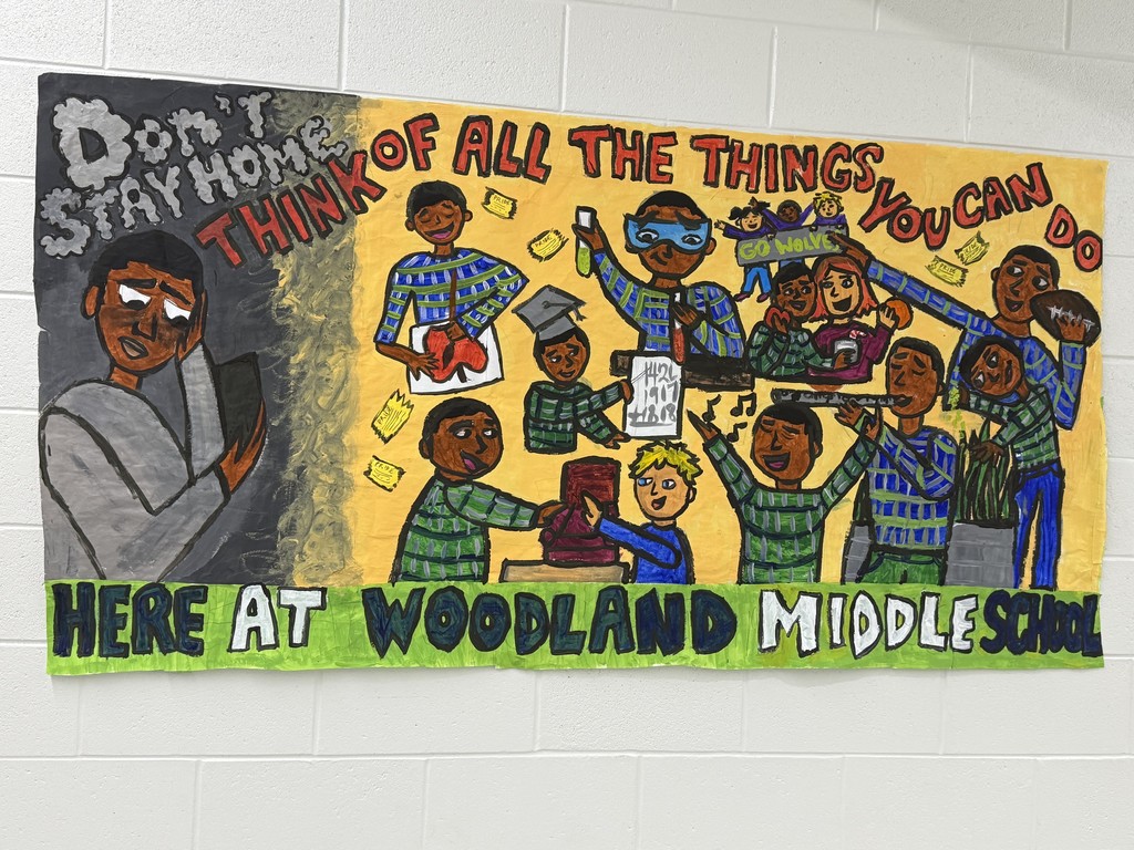 A hand-painted student mural for Attendance Awareness Month at Woodland Middle School. On the left, a student is shown in dull gray tones sitting sadly under the words “Don’t Stay Home.” The right side is vibrant and colorful, filled with drawings of students celebrating school life—graduating, reading books, playing sports, making music, cheering, and doing science. Text across the mural reads: “Think of all the things you can do here at Woodland Middle School.”