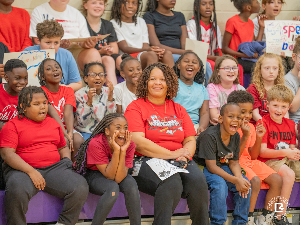 Students and staff in the bleachers laughing and cheering together during the Speak Life Day program. Smiles and joy are evident across the group.