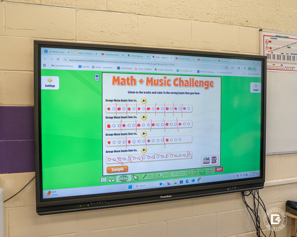 A classroom display screen shows the “Math + Music Challenge” program, instructing students to group beats into 2’s, 3’s, 4’s, and 6’s.